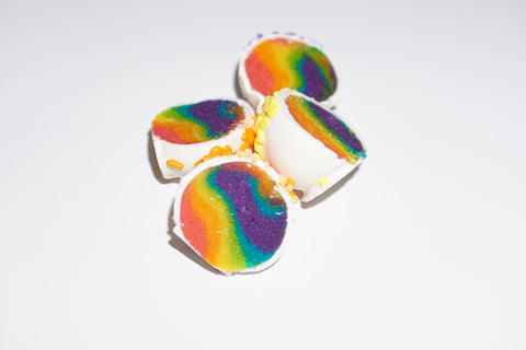 two rainbow cake balls cut in half