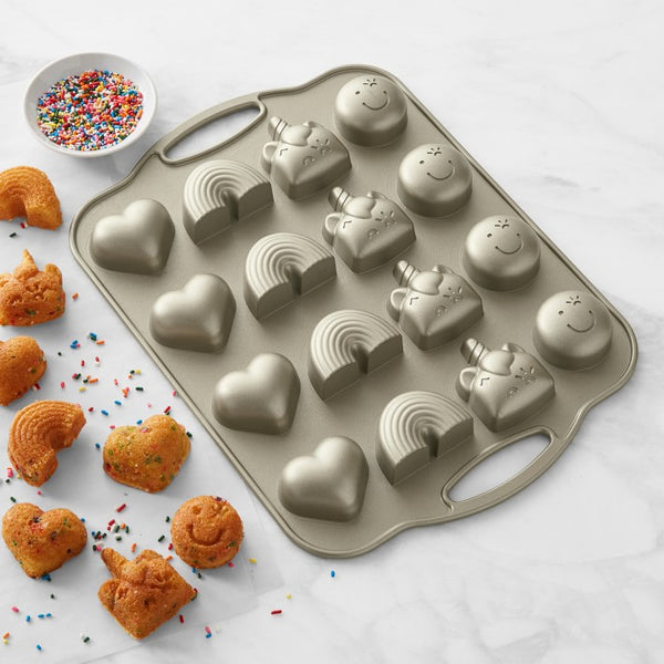 Cast-aluminum pan with 16 cake bites: 4 smiley faces, 4 unicorns, 4 rainbows and 4 hearts